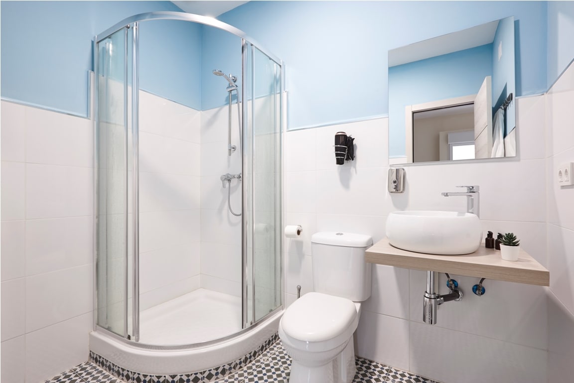 bathroom with shower cabin, sink and basin. hotel indoor