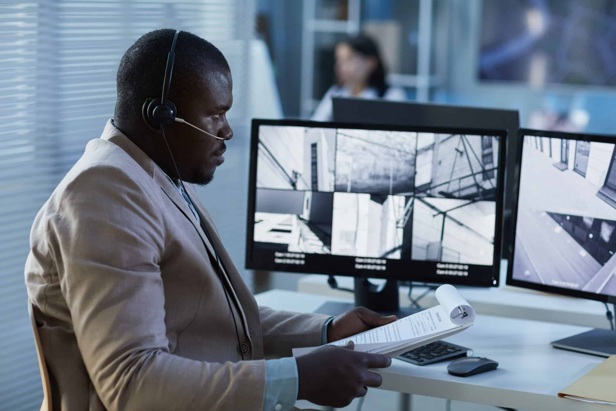 black man wearing headset while watching surveillance feed