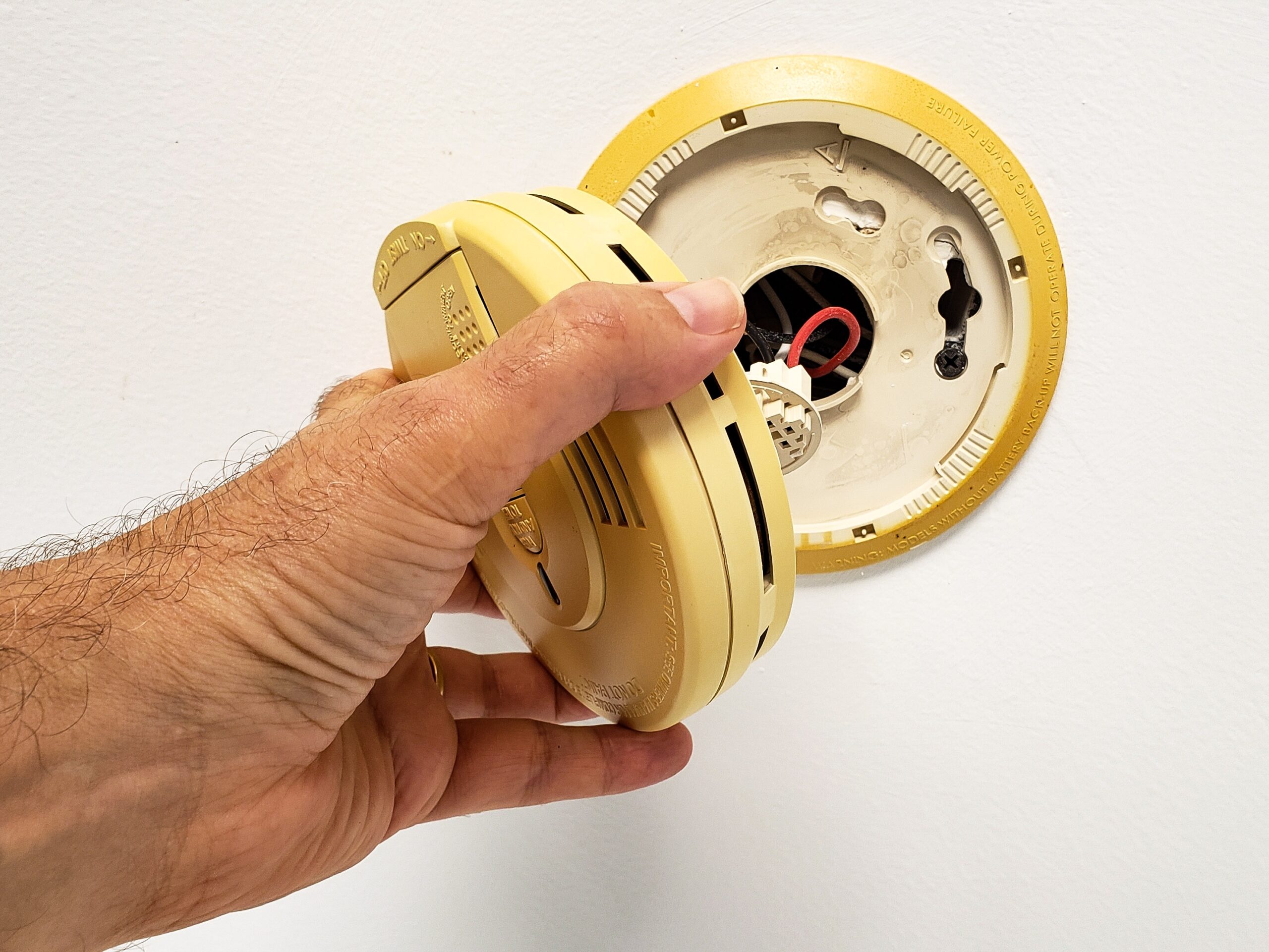 man hand opening up built in smoke alarm to change 2022 11 12 09 51 06 utc