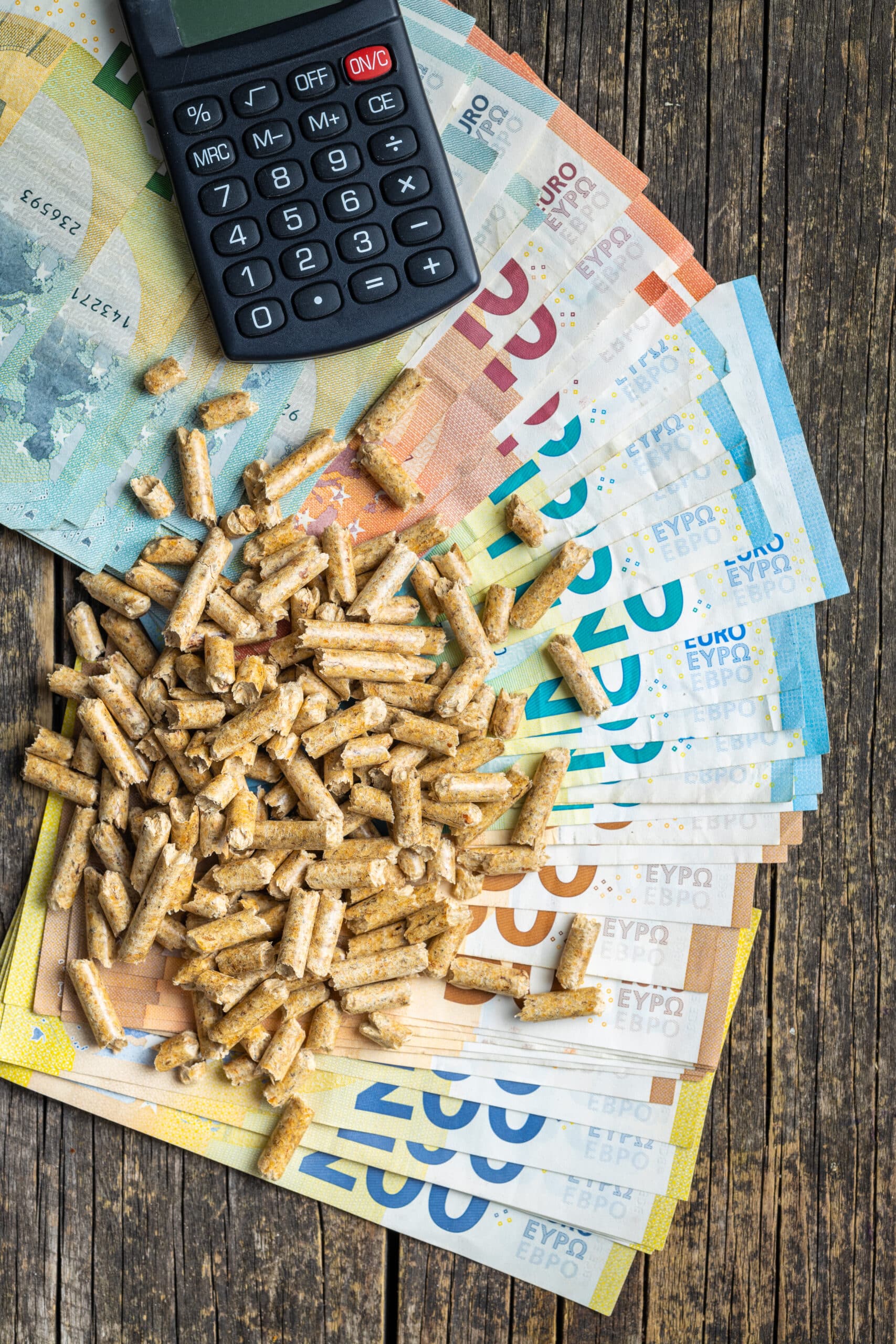 wooden pellets, calculator and euro money. concept of increasing energy prices.