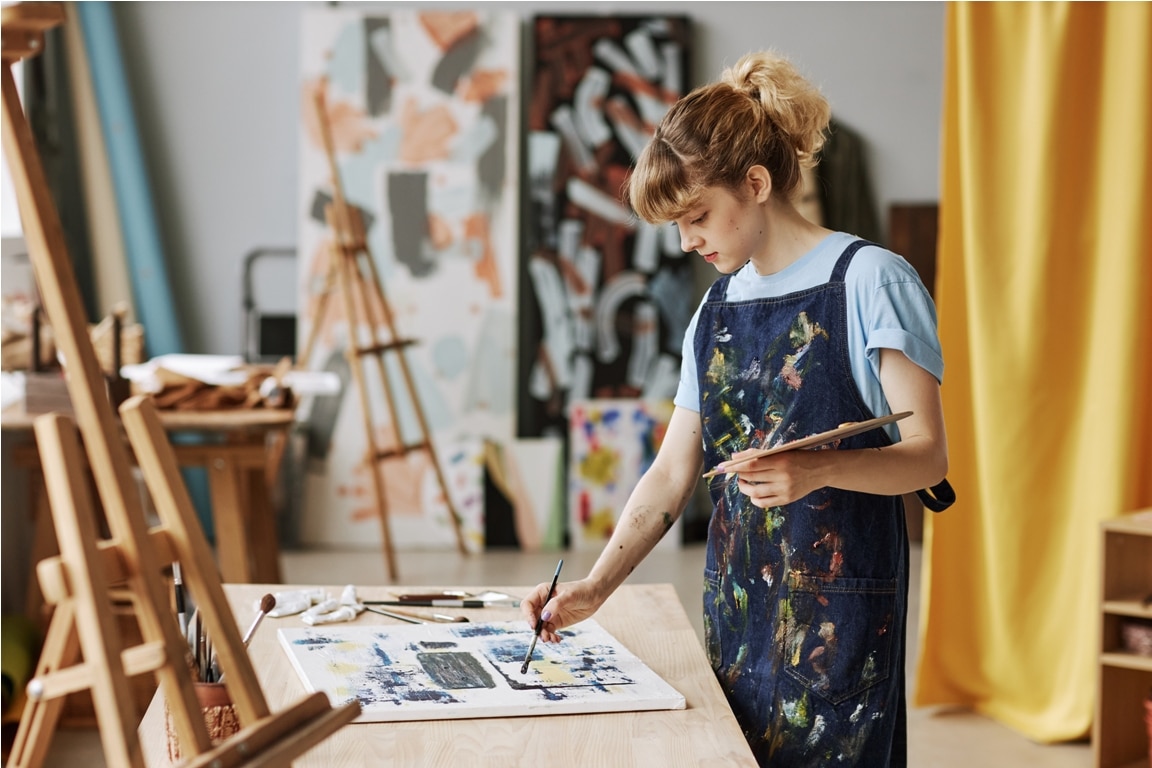 young inspired woman in apron painting with acryli 2022 11 17 12 21 52 utc