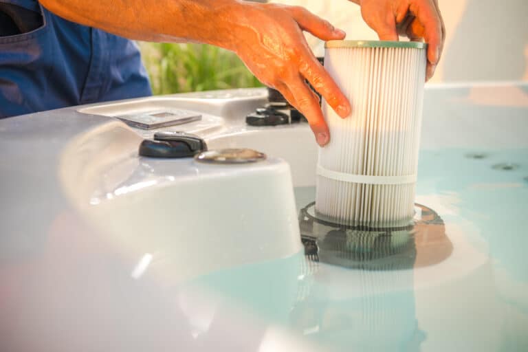 hot tub technician removing water filter and performing schedule