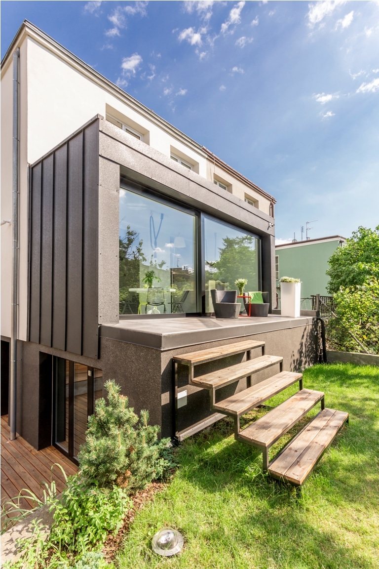 detached house with a veranda and wooden steps to the backyard