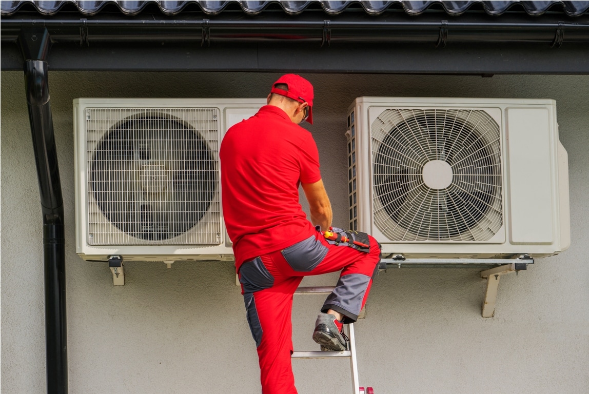 heating and cooling technician performing scheduled heat pump unit service