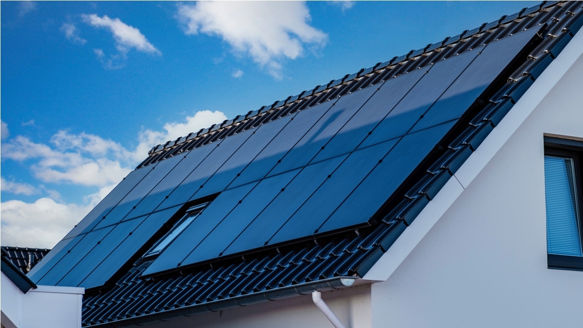 newly build houses with solar panels attached on the roof against a sunny sky