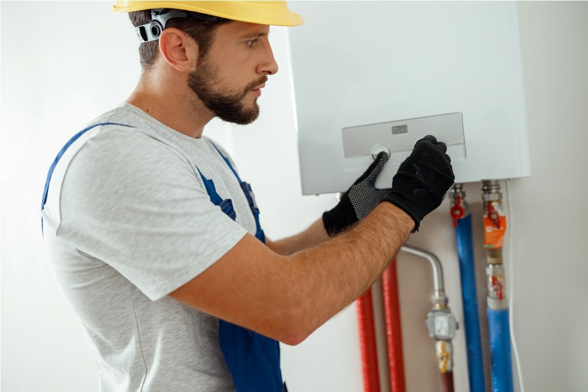 serious technician setting the new gas boiler for hot water and heating