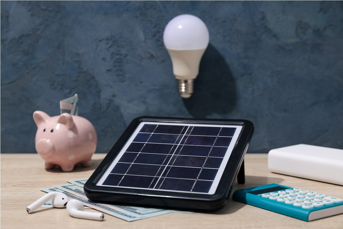 solar panel, light bulb and cash on blue background