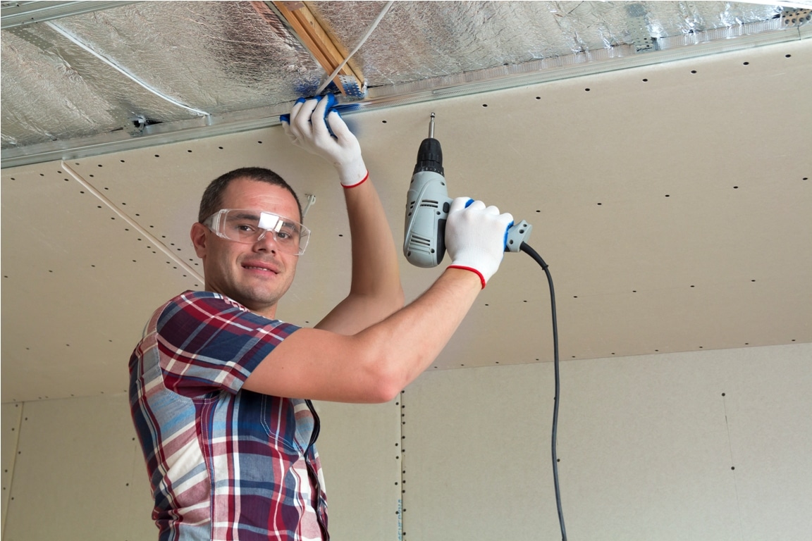 young man in goggles fixing drywall suspended ceil 2023 11 27 05 03 17 utc