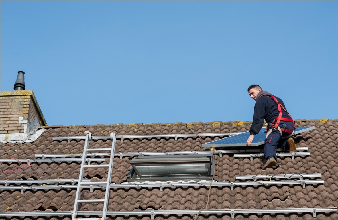 man putting the solar panel to the metal construction on the roof